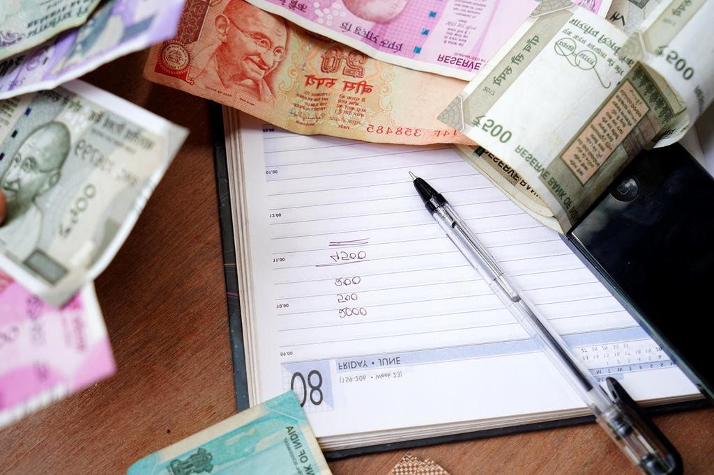 Person planning a budget with a calculator and notebook on a desk